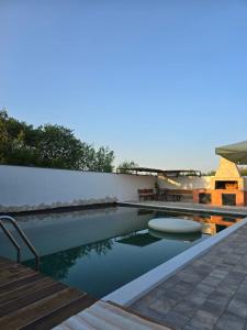 a swimming pool with a table and benches next to it at Villa Bali Serenity in Stolac