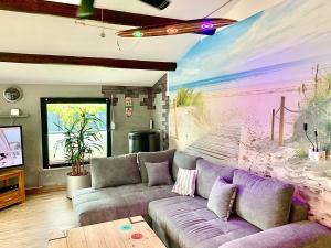 a living room with a couch and a painting on the wall at Aschenputtel Relax Bernsteinsee Stüde in Sassenburg