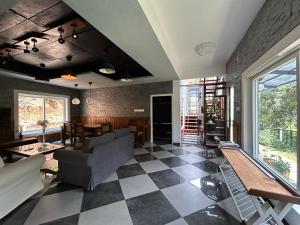 a living room with a checkered floor at Kayyath Valley Munnar - Luxury 4BHK Hillside Sanctuary in Anachal