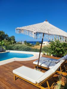 a umbrella sitting on a deck next to a swimming pool at Villa Solaris in Sounio