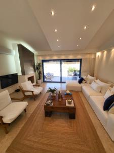 a living room with a white couch and a table at Villa Solaris in Sounio +92 photos