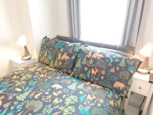 a bedroom with a bed with a patterned bedspread and two lamps at Amber Lodge- No party Room in Belfast