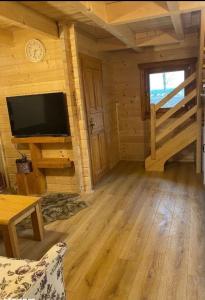 a log cabin living room with a flat screen tv at Ferienhaus Starzyska in Osówek