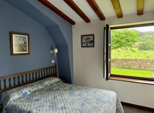 a bedroom with a bed and a window at Posada La Roblera in Oreña