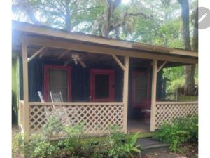 una piccola casa con portico con porta rossa di Fisherman's Cabin a New Port Richey
