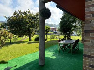 奧瑞那Apartamentos la Roblera的绿色草坪上的桌椅