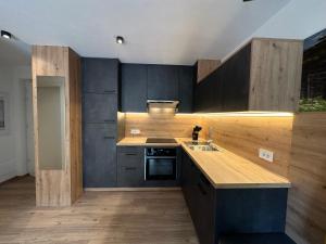 a kitchen with black cabinets and a wooden counter top at SiJa in Mühlbach +4 photos
