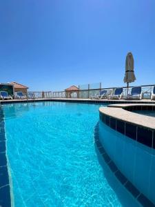 a large swimming pool with blue water and chairs at Luxurious heart flat in Hurghada