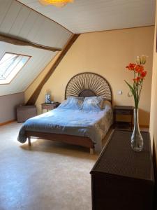 1 dormitorio con 1 cama y un jarrón con flores en les trois monts, en Sère-Lanso