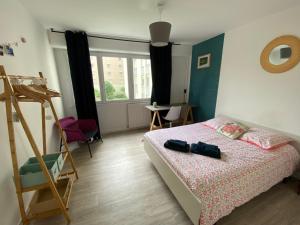 1 dormitorio con cama, escalera y ventana en Cosy flat 2 chambres, en Saint-Étienne