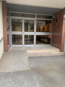 una entrada a un edificio con puertas de cristal en Cosy flat 2 chambres, en Saint-Étienne