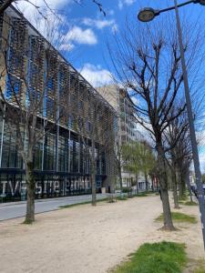 un edificio en una ciudad con árboles delante en Cosy flat 2 chambres, en Saint-Étienne