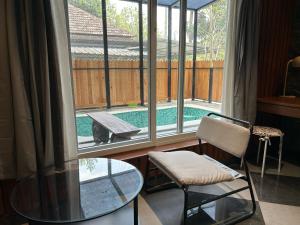 a room with a glass table and a window with a pool at Kayyath Valley Munnar - Luxury 4BHK Hillside Sanctuary in Anachal