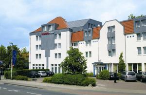 a large white building with an orange roof at IntercityHotel Celle in Celle