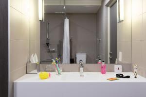 a bathroom with a sink and a large mirror at Moxy Aberdeen Airport in Dyce