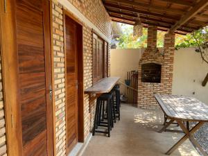 a patio with a table and chairs and a fireplace at Casamarias duplo in Barra Grande