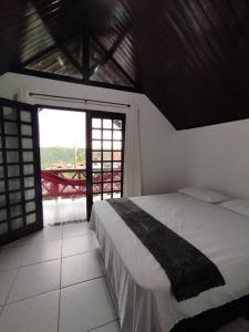 a bedroom with a bed and a large window at Chalé Paisagem Serrana in Bananeiras +11 photos