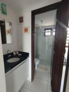 a bathroom with a shower and a sink and a toilet at Bananeiras - Chalé 204 in Bananeiras
