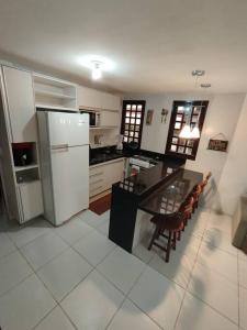 a kitchen with a refrigerator and a table and chairs at Bananeiras - Chalé 204 in Bananeiras