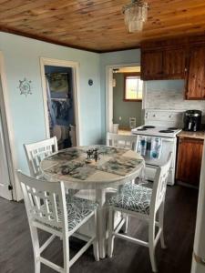 a kitchen with a table and chairs and a stove at Sea Captains Cabin in Lamaline +19 photos
