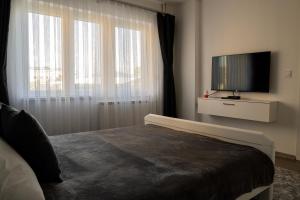 a bedroom with a bed and a flat screen tv at Fantasy apartment in Skopje