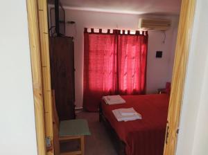 a bedroom with a red bed and a red window at Los Fresnos Casa Quinta in La Picada