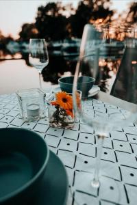 a table with two glasses and a flower on it at Hausboot Urlaub in Ostfriesland auf der Waterhome 1 in Großefehn  +11 photos
