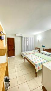 a bedroom with two beds in a room at Pousada Do Vozinho in Touros +37 photos