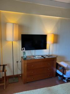 une pièce avec deux lampes et une télévision sur une commode dans l'établissement Semanas 30 e 24 Vila Galé Cerro Alagoa, à Albufeira