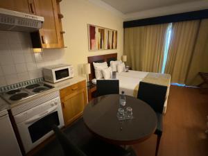 - une petite cuisine avec une table et un lit dans l'établissement Semanas 30 e 24 Vila Galé Cerro Alagoa, à Albufeira