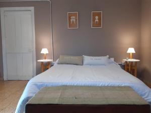 a bedroom with a large bed with two lamps at LA ROTONDA in San Nicolás de los Arroyos
