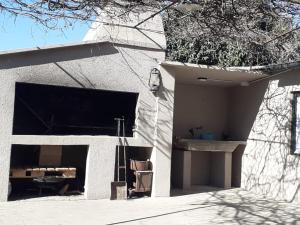 a white building with a garage with a window at LA ROTONDA in San Nicolás de los Arroyos
