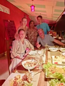 a group of people sitting at a table in a restaurant at Greenbury Kite Hostel & Restaurant in Kalpitiya