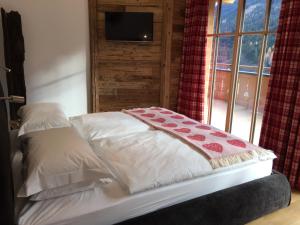 a bed in a room with a window at The Bear's Lair in Saalbach Hinterglemm