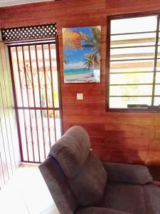 a living room with a couch and two windows at Kreyolita in Saint-Laurent du Maroni
