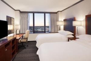 a hotel room with two beds and a desk and a television at Sheraton Anchorage Hotel in Anchorage