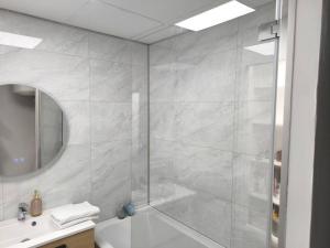 a bathroom with a shower and a tub and a sink at Magnifique Studio Douillet in Le Mans