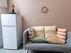 a room with a couch with pillows and a clock on the wall at Magnifique Studio Douillet in Le Mans