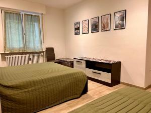 a bedroom with two beds and a desk and a window at Casa di Chiara Andalo Centro in Andalo