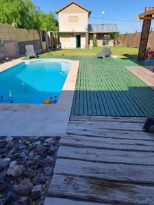 una piscina con terrazza in legno accanto a una casa di Casa con pileta y vista a la montaña a El Challao
