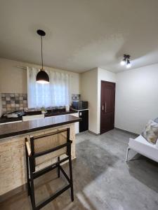 une cuisine avec un banc au milieu d'une pièce dans l'établissement Ninho dos Pássaros Chalés, à Monte Verde