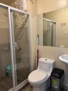 a bathroom with a toilet and a shower and a sink at Cozy & Homey Avida Towers Tower 2 in Davao City