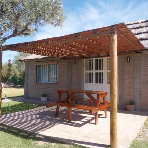 a wooden picnic table under a wooden pergola at Cabaña Doña Alicia in San Rafael