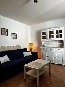 a living room with a blue couch and a table at Cabaña Amida in Lajares