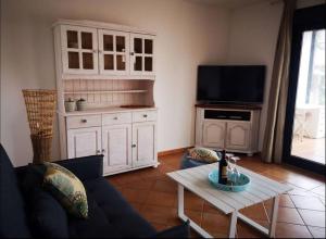 a living room with a couch and a tv and a table at Cabaña Amida in Lajares