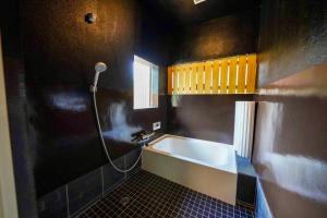 ein Badezimmer mit Badewanne und Fenster in der Unterkunft SORANIWA glamping in Iimorikōzan