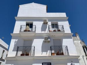 - un bâtiment blanc avec balcon dans une rue dans l'établissement Molinero, à Vejer de la Frontera