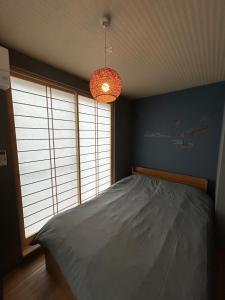 東京にあるTwo Point Sevenのベッドと大きな窓のある寝室