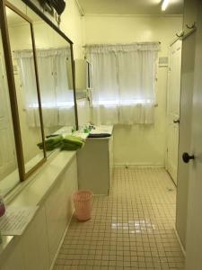 a small kitchen with a sink and a mirror at Kandos Cottage in Kandos