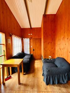 a room with two beds and a table in it at Puerto Río Tranquilo in Puerto Tranquilo